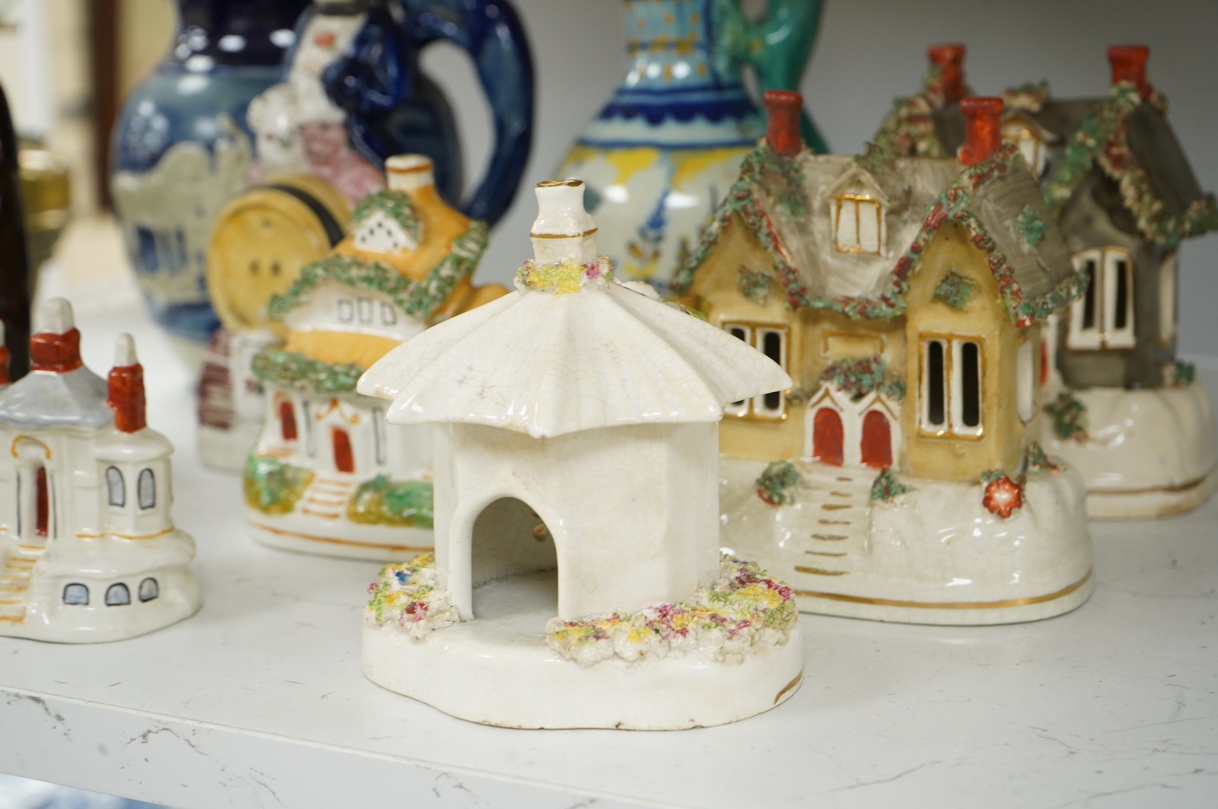 A group of various Victorian Staffordshire pottery models of cottages and various figure moulded vessels together with an Italian maiolica ewer, tallest 25cm